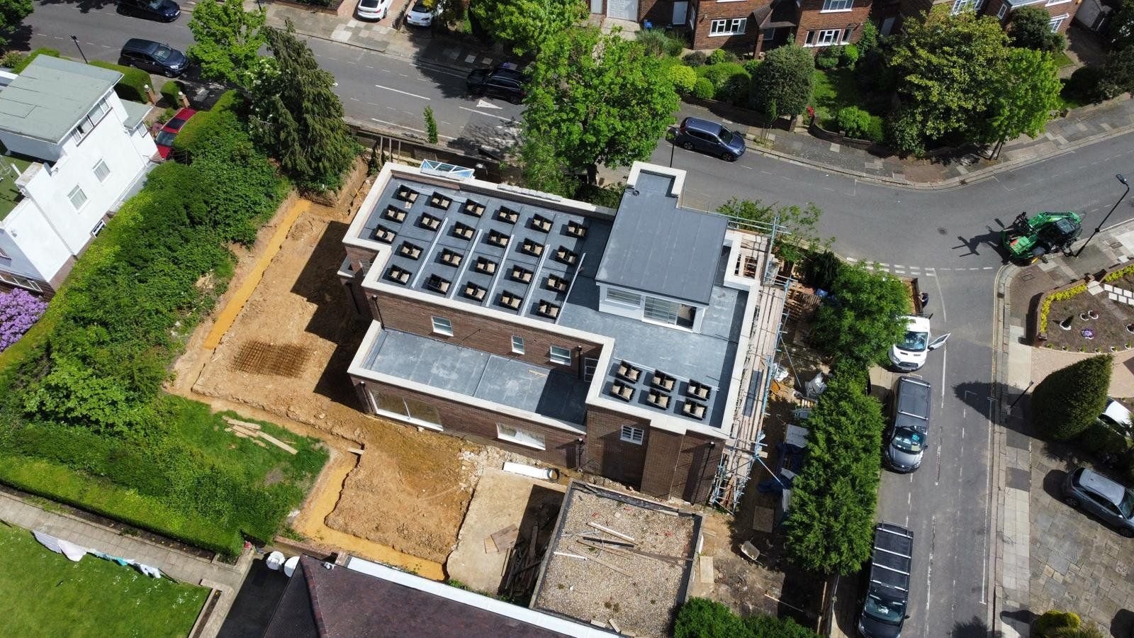 Aerial view of a flat-roofed building with Fast Tub units and ballast laid out across the roof before panel installation
