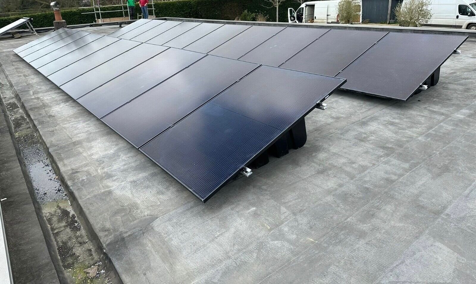 Full-size solar panels mounted in landscape at 13 degrees across a completed Fast Tub array on a flat roof